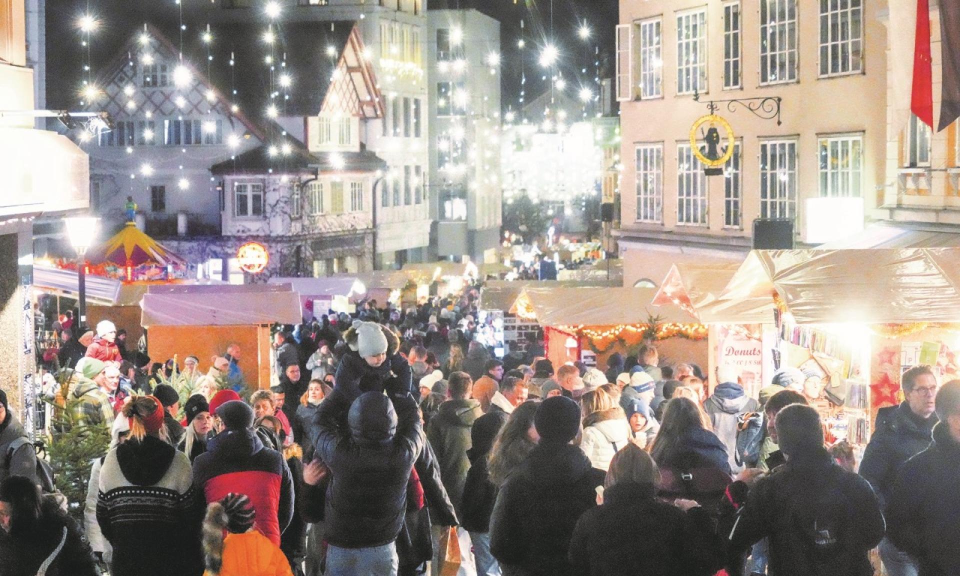 Einsiedler Weihnachtsmarkt auf der Hauptstrasse Richtung Dorfzentrum mit festlicher Strassenbeleuchtung