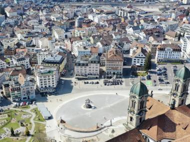 Vogelperspektive auf die Kirchtürme des Klosters Einsiedeln und auf das Dorf Einsiedeln.